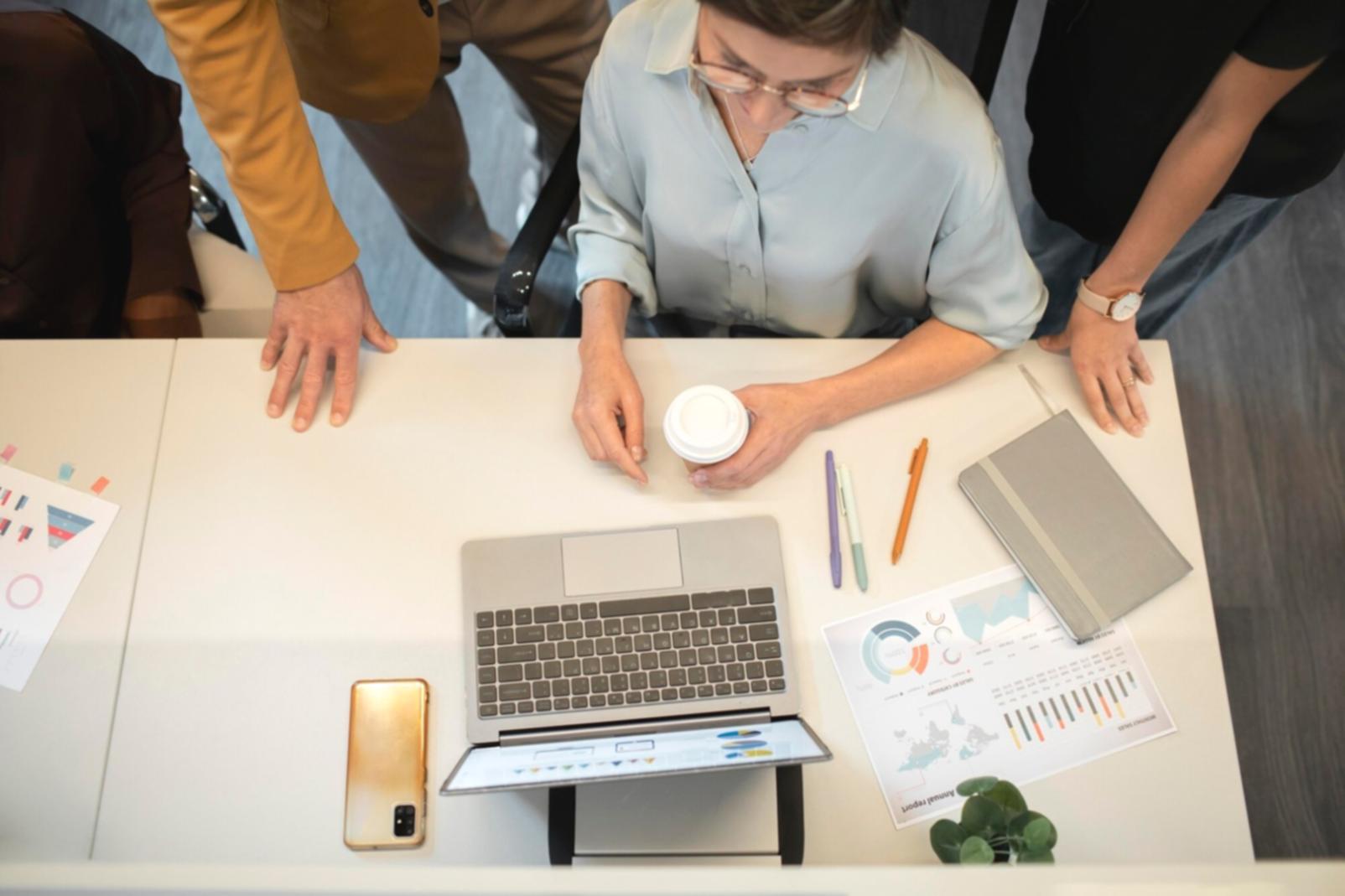 Espace de travail avec documents financiers et ordinateur montrant des analyses